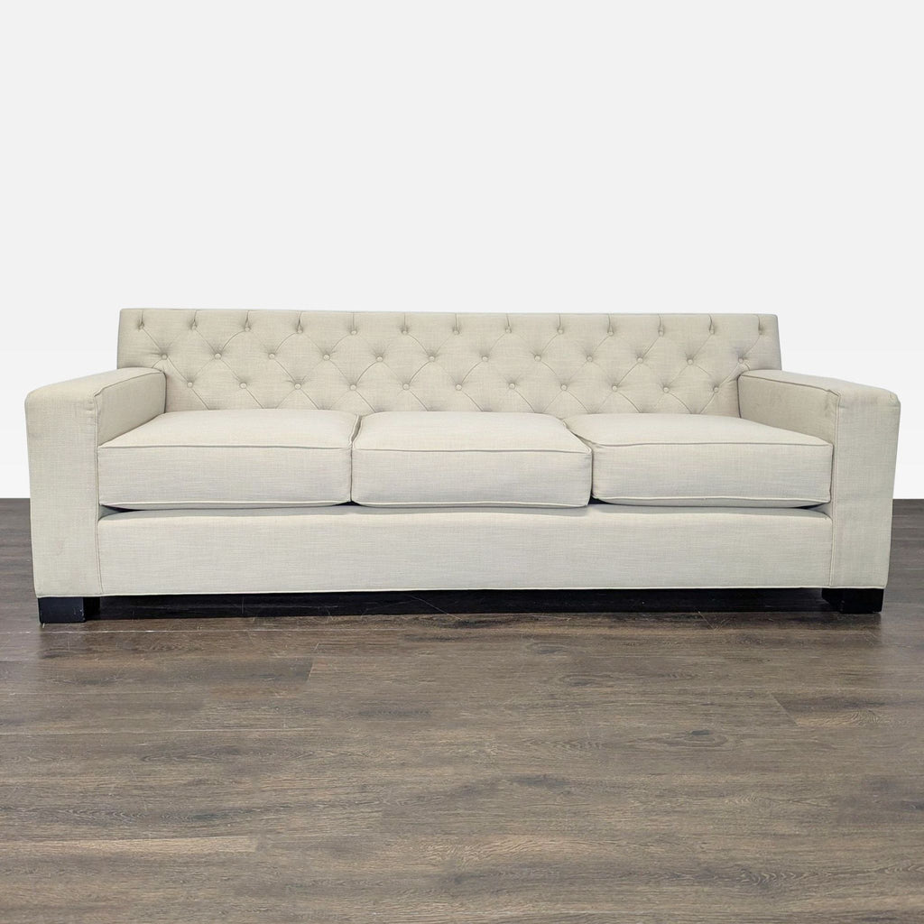 Modern beige 3-seat sofa with tufted backrest, square arms, and plush cushions, ideal for living areas.