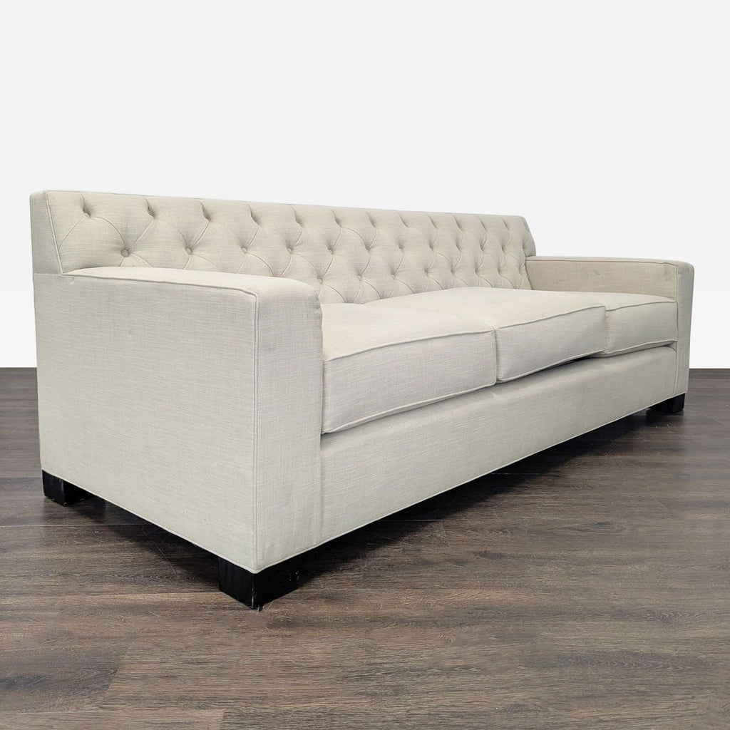 Contemporary 3-seat sofa in beige fabric features thick cushions and classic tufted back, suitable for any décor.