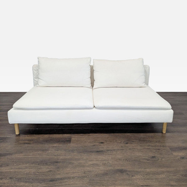Ikea loveseat with white fabric and wooden legs, seating two, ideal for modern apartments or offices.  