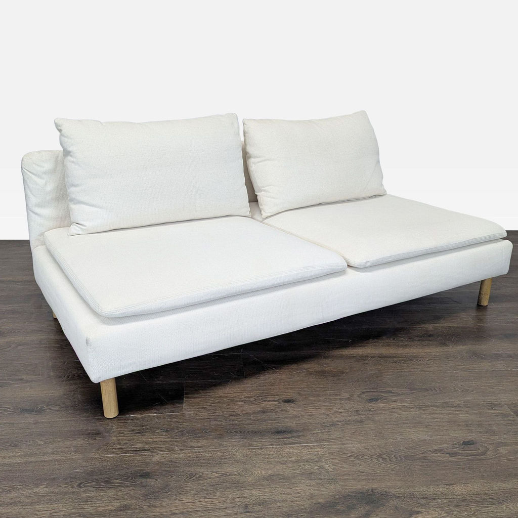 Modern white Ikea loveseat with plush cushions and simple wood legs, perfect for small living spaces.  
