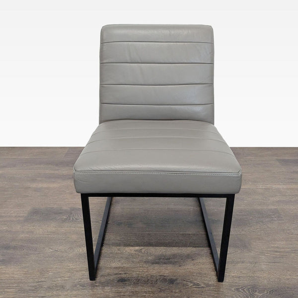 Crate & Barrel leather dining chair with channel tufting and metal sled legs.  