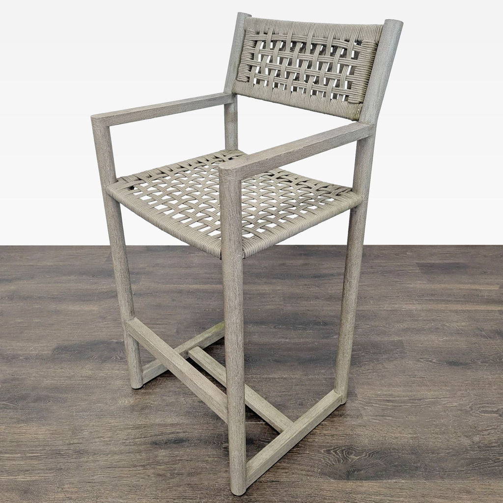 Stylish woven bar chair by Restoration Hardware in teak wood, designed for comfort and durability.