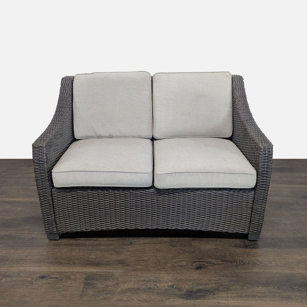 Threshold loveseat chair with dark wicker frame and light gray cushions, seats two, suitable for indoor or outdoor use.