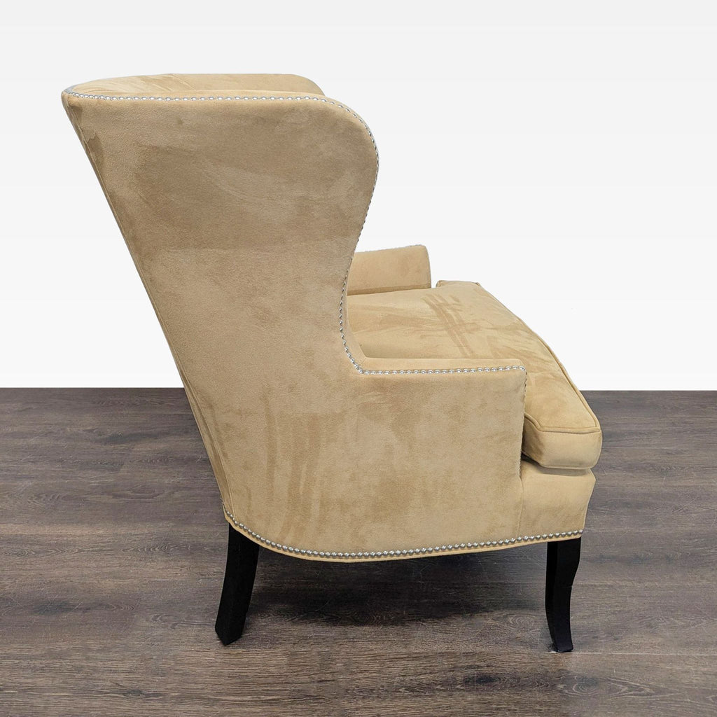 Elegant tan upholstered lounge chair by Williams Sonoma Home, featuring nailhead detail and high-back design.  