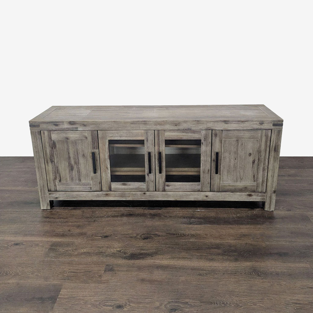 Rustic gray Macy’s media console with four doors, glass panels, and shelves for electronics and media storage.