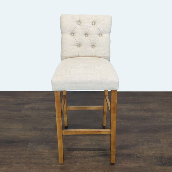 Button-tufted stool with soft seat and sturdy wooden legs, ideal for seating or decor.  