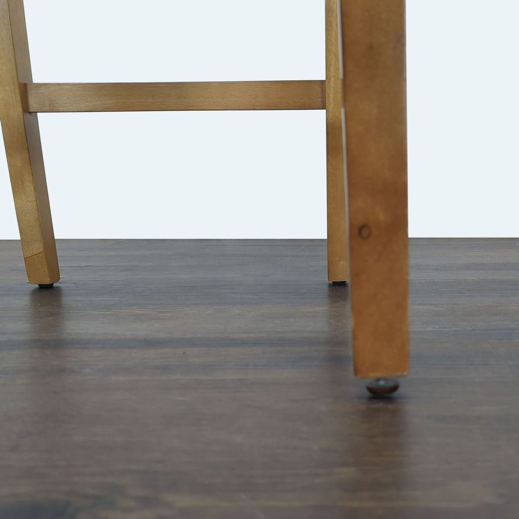 Upholstered cushioned bench with tufted backrest atop four wooden legs, perfect for living spaces.  