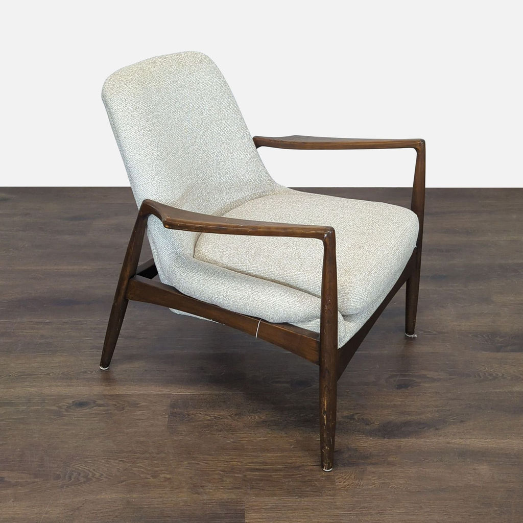 Four Hands lounge chair featuring angled dark wood arms and legs with cozy, light-colored fabric seat.