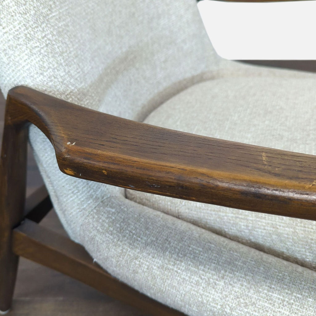 Sleek Four Hands lounge chair in light fabric and sturdy wood, perfect for stylish lounge areas.