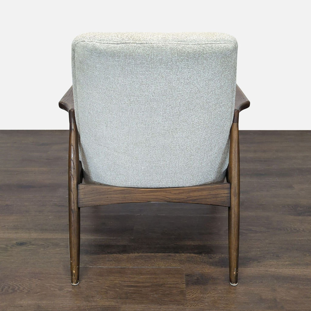 Modern lounge chair by Four Hands with dark wood frame and light textured upholstery, ideal for relaxation.