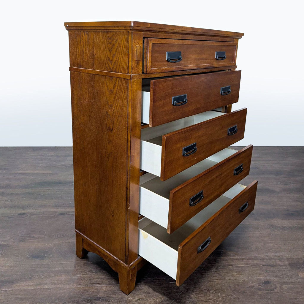 2. Side angle of Ashley Furniture dresser showing five partially open drawers, sturdy design, black metal handles.  