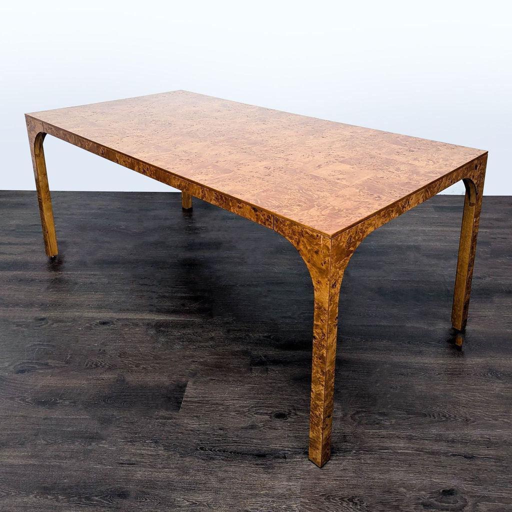 Lacquered CB2 table with continuous burl wood flow and arching legs, reminiscent of Roman aqueduct structures.