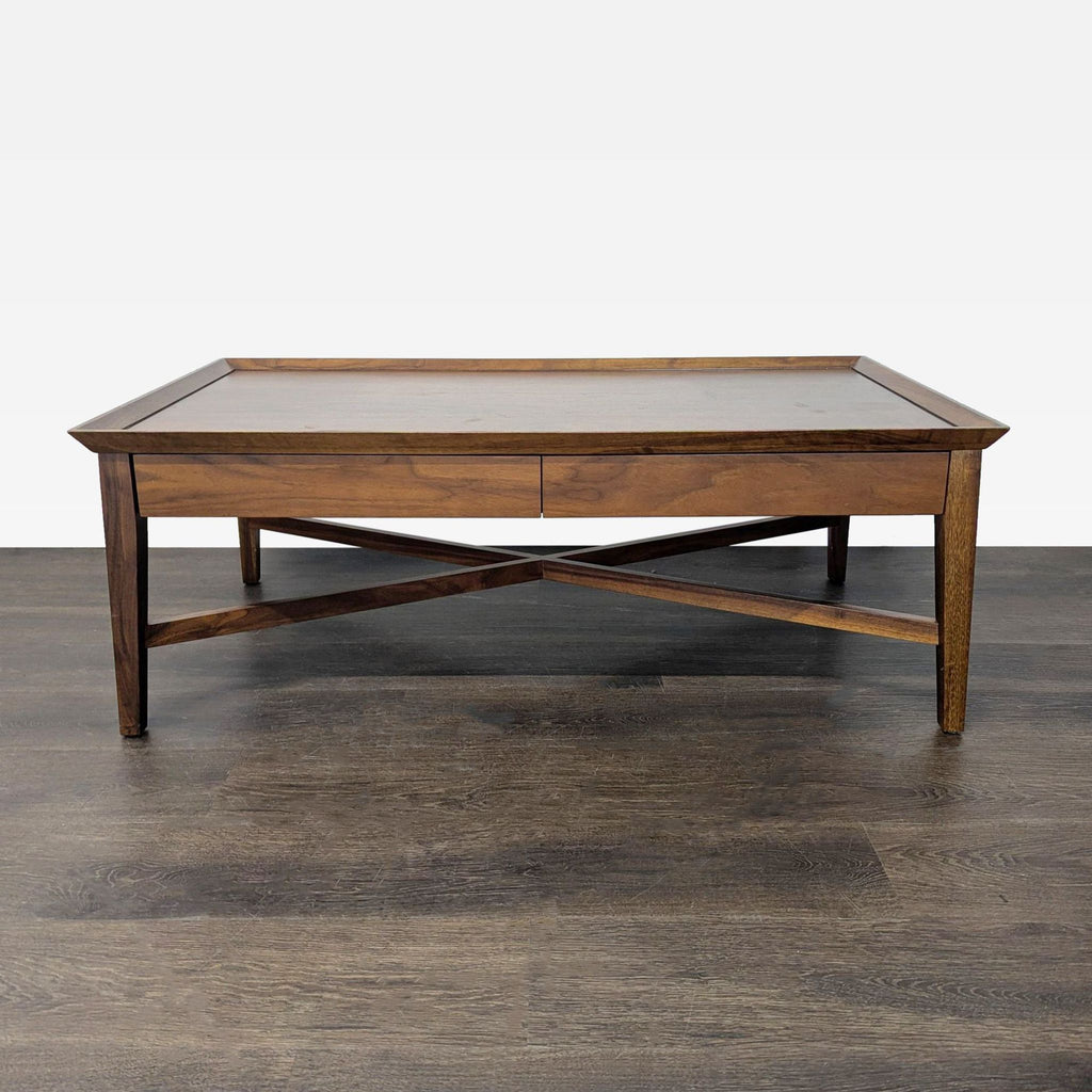 Crate & Barrel walnut coffee table with X-braced sides and two drawers for storage.
