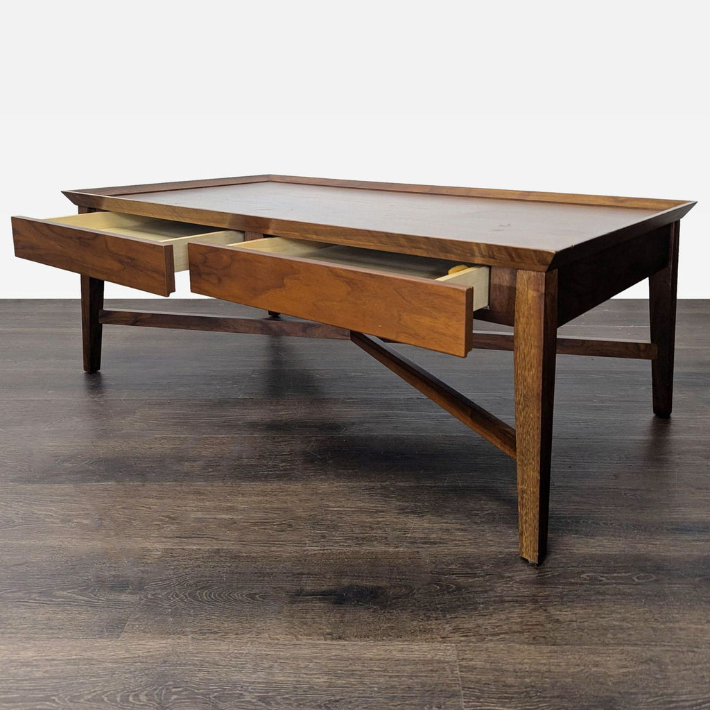 Modern two-drawer coffee table in walnut finish, featuring signature X-brace design.