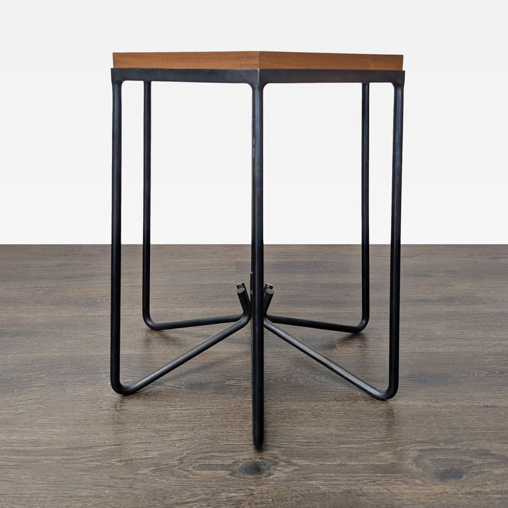 2. Close side view of a metal base side table featuring a hexagonal wooden tabletop.