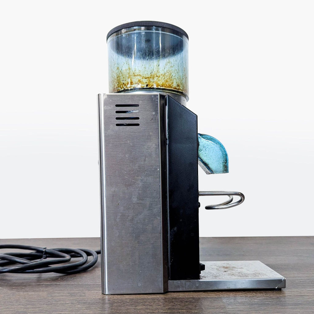 Rancilio Rocky grinder for fresh coffee, visible wear, adjustable grind, ideal for daily home use.