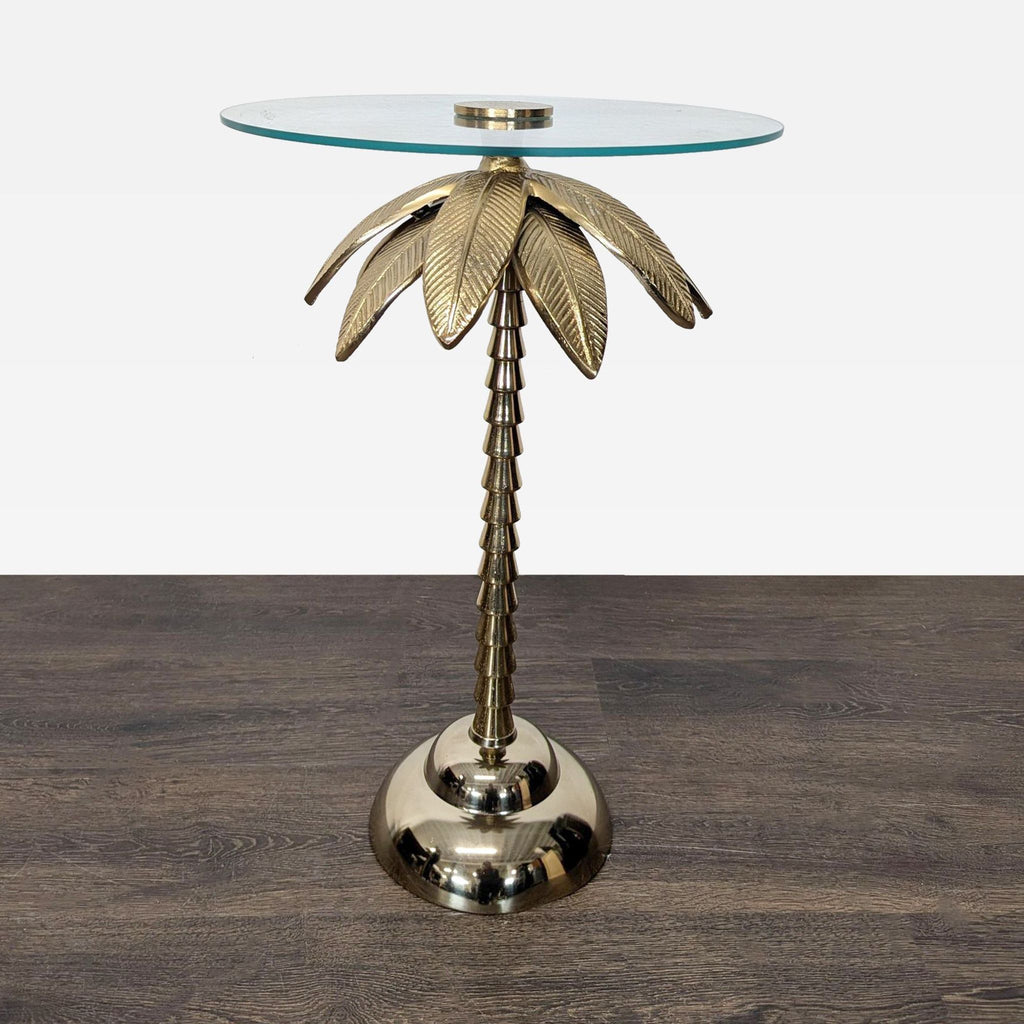 Glass side table with gold palm tree-shaped metal base and round glass top.  