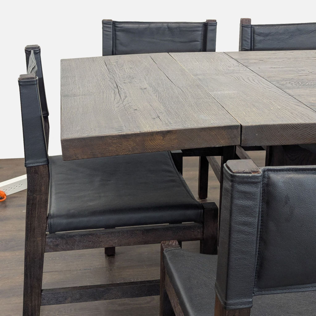 Rustic solid wood dining set featuring eight black leather Pottery Barn chairs and a Restoration Hardware table.