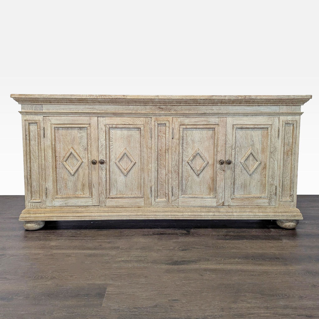 Washed grey sideboard with diamond-paneled doors, bun feet, and interior shelves for storage.  