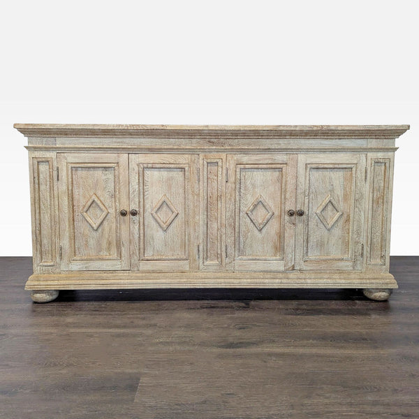 Washed grey sideboard with diamond-paneled doors, bun feet, and interior shelves for storage.  