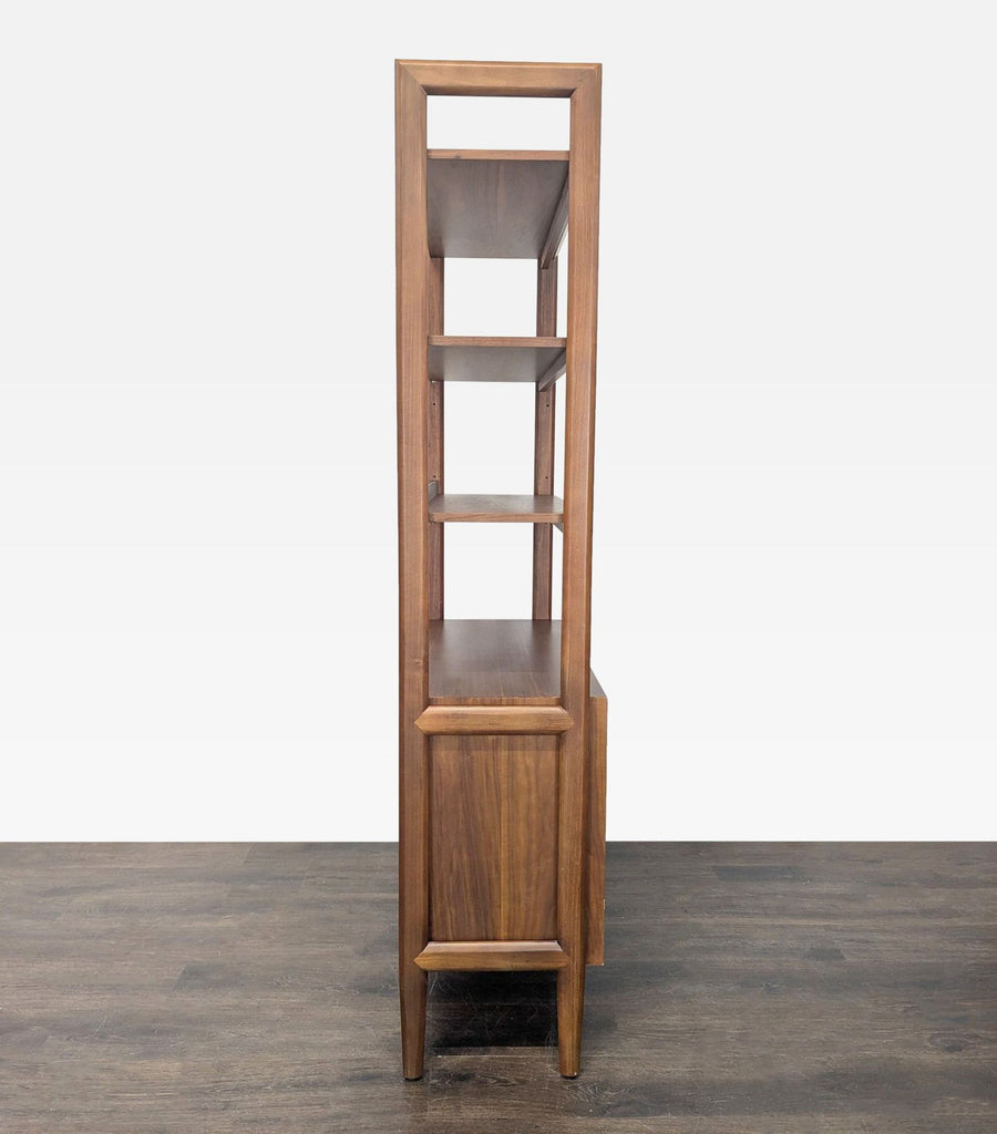 Contemporary Crate & Barrel bookcase with three shelves and a closed cabinet, ideal for organized storage.