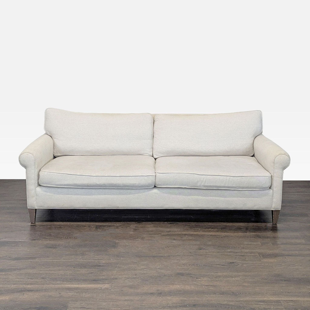 Crate & Barrel 3-seat sofa with light beige fabric, plush cushions, and wooden legs in a timeless design.