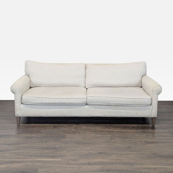 Crate & Barrel 3-seat sofa with light beige fabric, plush cushions, and wooden legs in a timeless design.