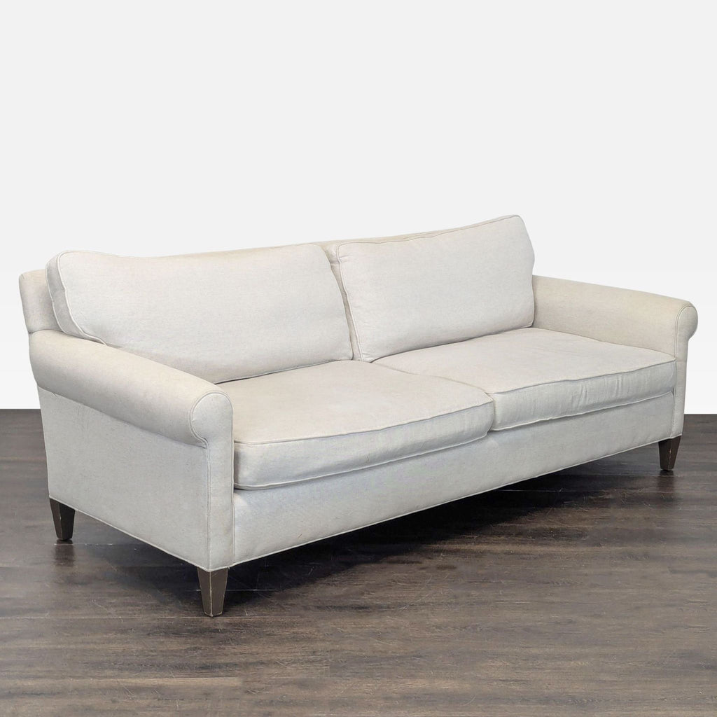 Elegant beige 3-seat sofa from Crate & Barrel features comfortable cushions and sturdy wooden legs, fitting any decor.