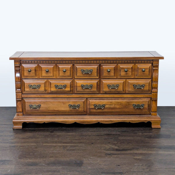 Classic Sumter dresser in wood finish with nine drawers and vintage brass handles, shown from the front.