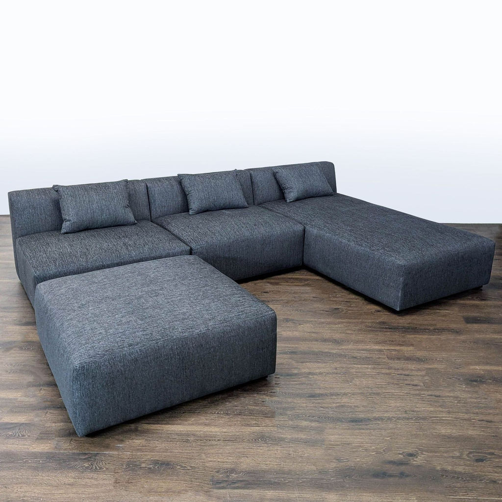 Maiden Home sectional sofa in dark gray fabric featuring a chaise and ottoman, designed for comfort and elegance.