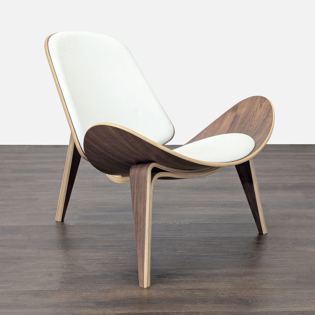 2. Side view of a stylish lounge chair featuring a sleek curved wood body, white cushion, and unique three-leg style.