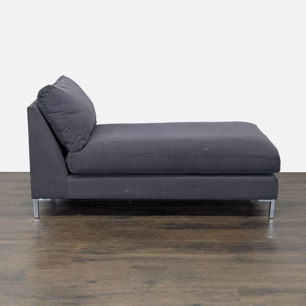 CB2 chaise lounge in dark gray fabric, featuring clean lines, supportive backrest, and stylish metal legs.