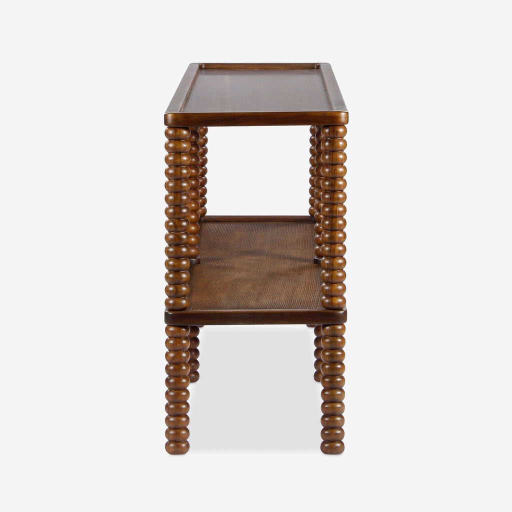 2. Side view of the Lulu and Georgia console table with spindle-style turned wood legs and a caned shelf.