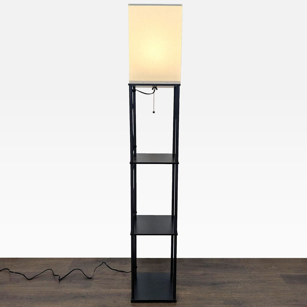 Tall floor lamp with a square fabric shade, pull chain, and three black display shelves, perfect for multiple rooms.