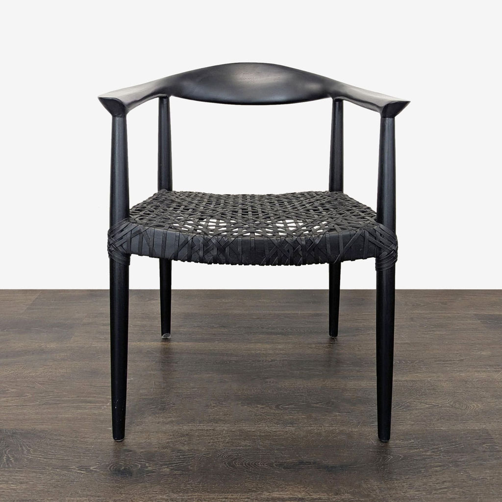 Black teak dining chair by Safavieh Home with woven cowhide leather seat and sculptural spindle legs.  