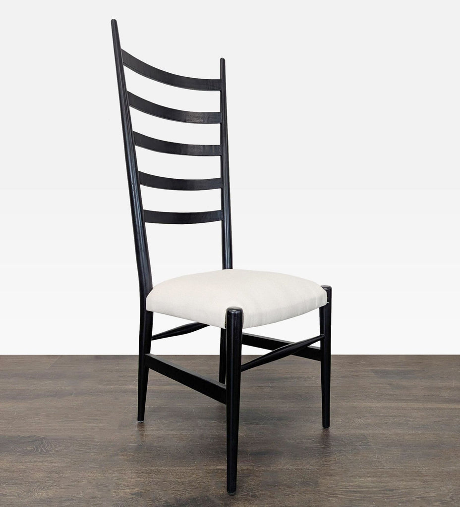 Side angle view showing sleek black chair frame with five ladder-back slats and a plush white seat.  