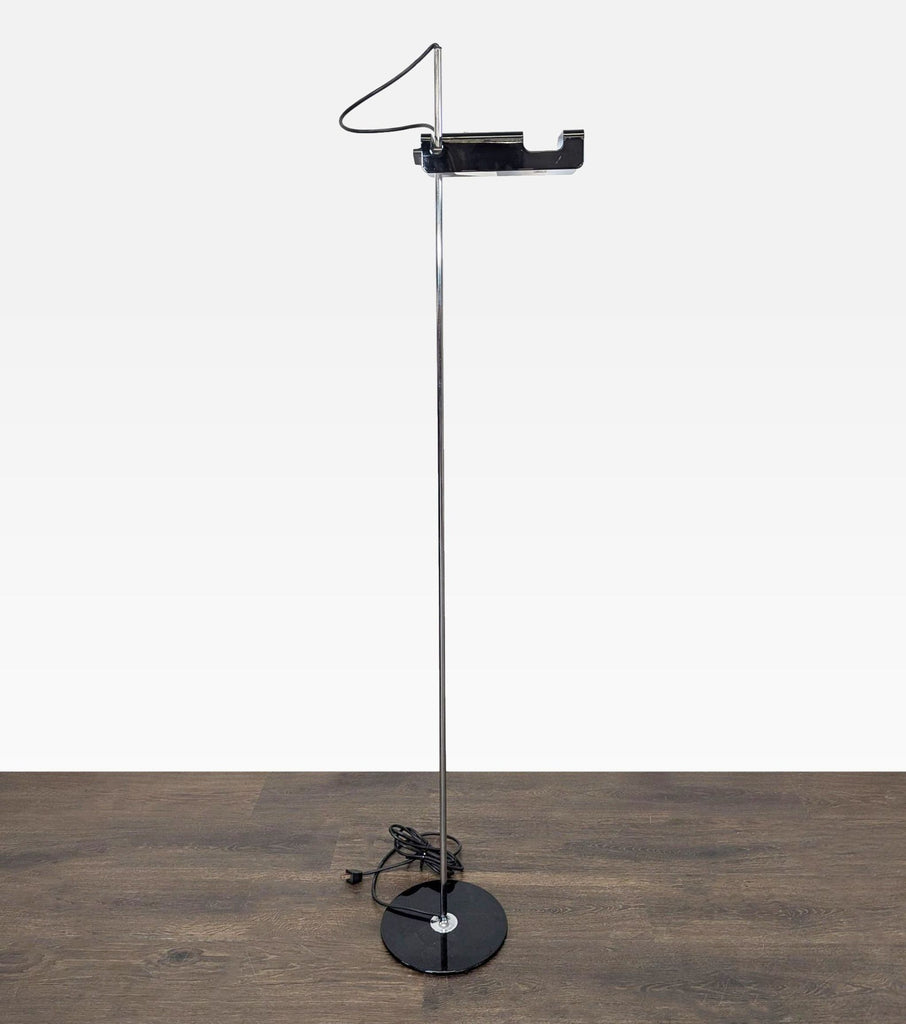 Contemporary floor lamp with black base and chrome stand; distinct adjustable head, designed by Joe Colombo for Oluce.