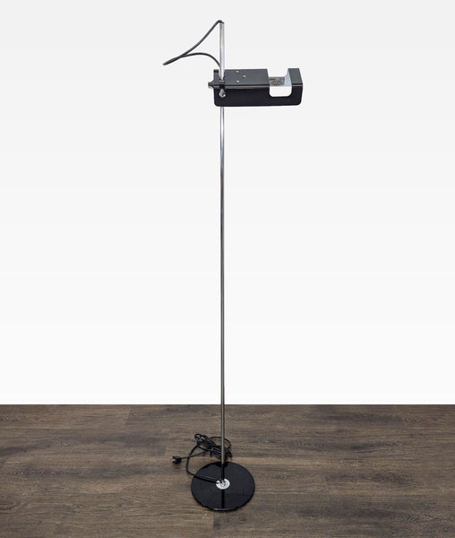Slim floor lamp by Joe Colombo for Oluce with chrome pole, black base, and adjustable head, modern minimal style.