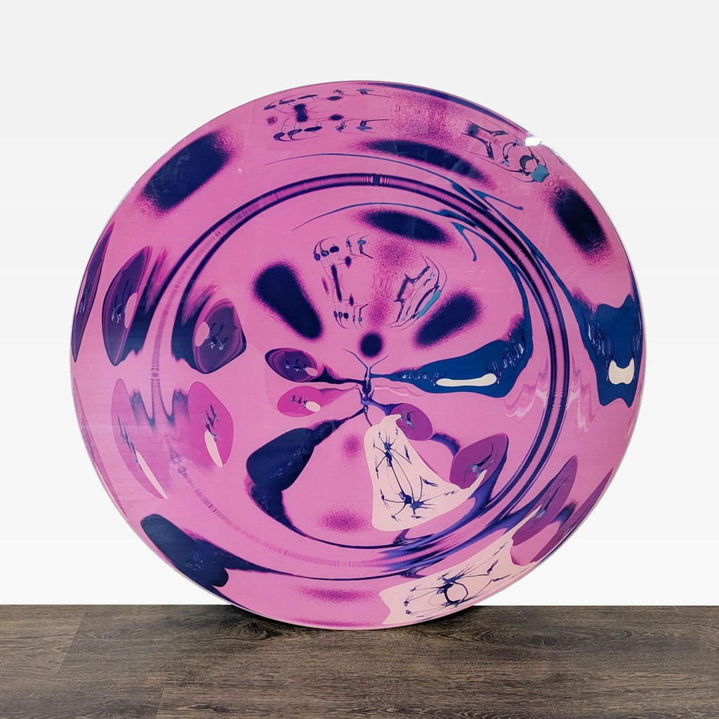 Round abstract painting by Mette Tommerup featuring pink and dark blue vibrant shapes on a modern canvas.  