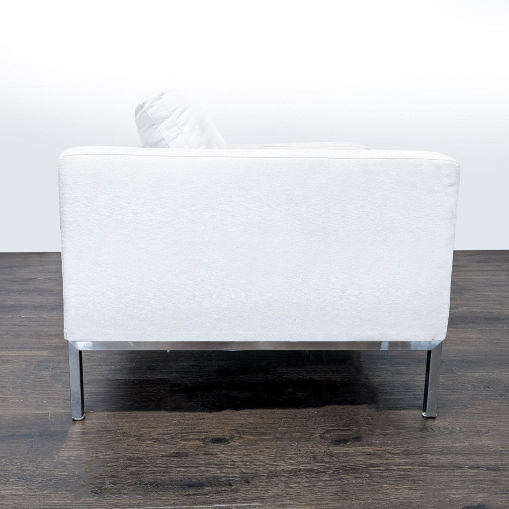 3. Minimalist white lounge chair with squared arms and chrome legs, side profile view for lounge or living rooms.