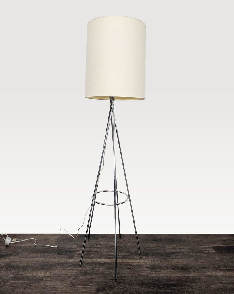 2. Sleek chrome tripod floor lamp with a simple white drum shade, ideal for living rooms or offices.  