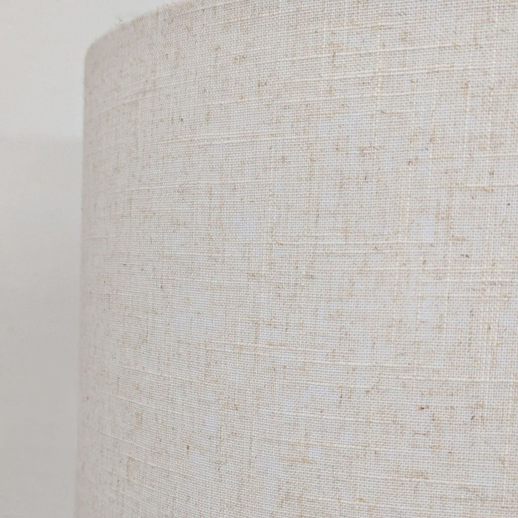 Contemporary floor lamp with tripod legs, integrated shelf, and soft white shade, perfect for any room.