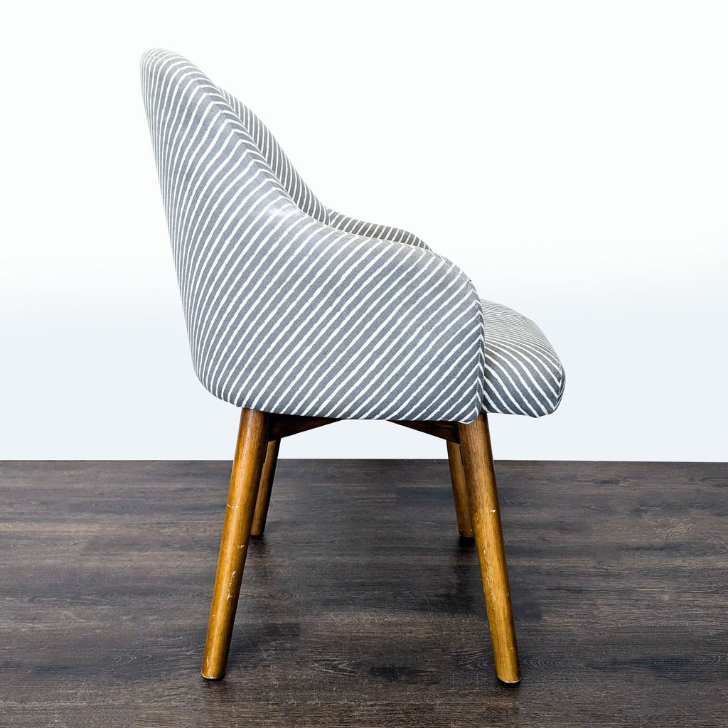 West Elm lounge chair featuring curved arms, stylish stripes, and a stable wooden swivel base for modern comfort.