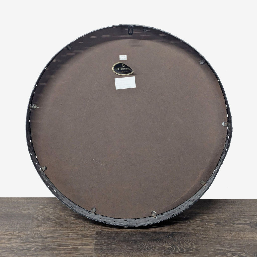 2. Rear view of Uttermost round mirror showing deep pierced metal frame and attached mounting hardware.