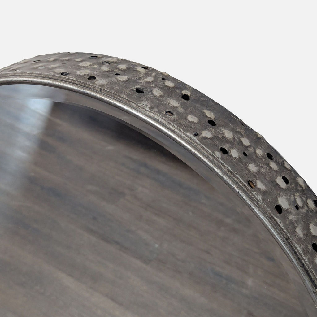 3. Close-up of pierced hammered metal frame finished in burnished gray, highlighting the mirror’s deep profile.
