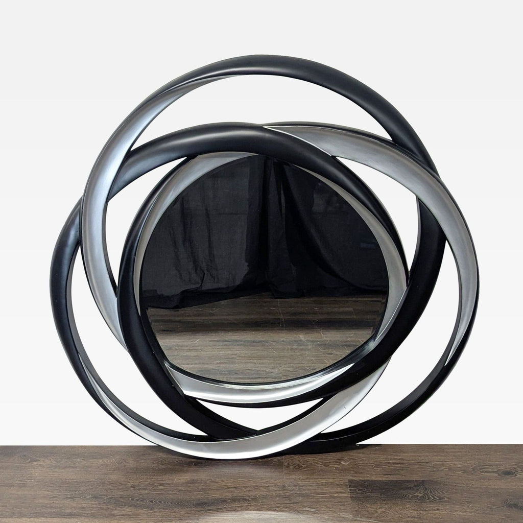 Coaster mirror with interlocking loops in silver and black high gloss finishes.  