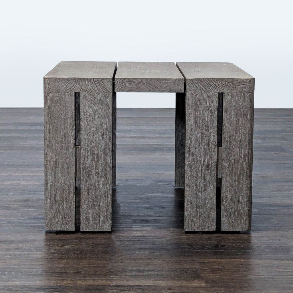 Modern block side table by Restoration Hardware with slatted top and weathered teak finish, shown from the front.