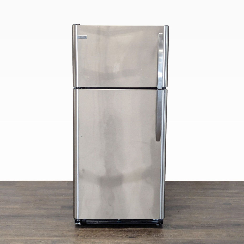 Frigidaire stainless steel refrigerator with top freezer, compact size, easy-grip handles, and organized storage.