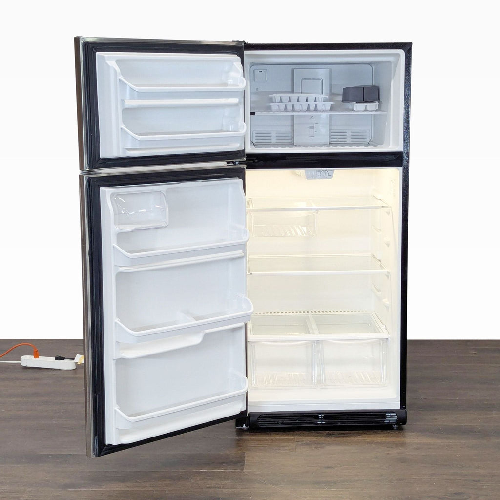 Compact Frigidaire refrigerator, modern stainless steel, top freezer, user-friendly handles, and spacious interior.