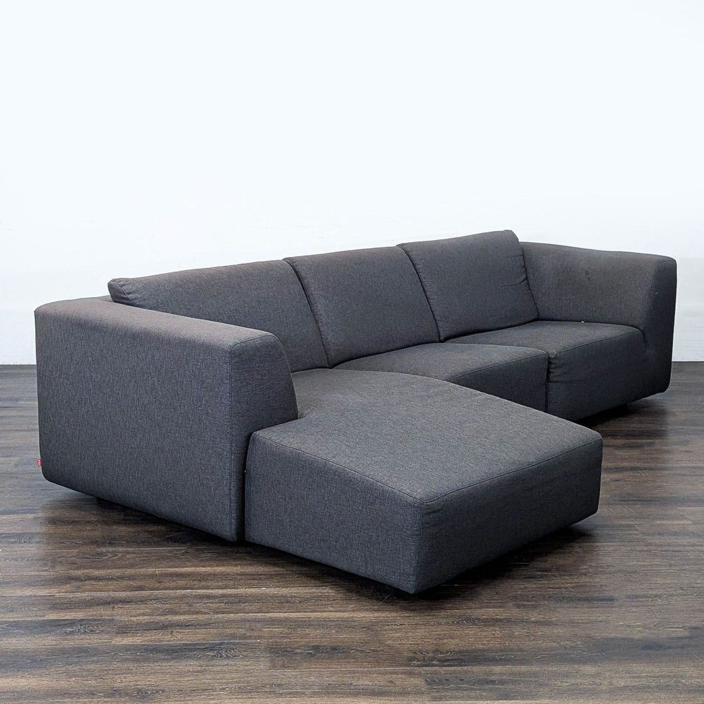 2. EQ3 sectional sofa in charcoal fabric, left-arm chaise, shown from an angled side perspective.  